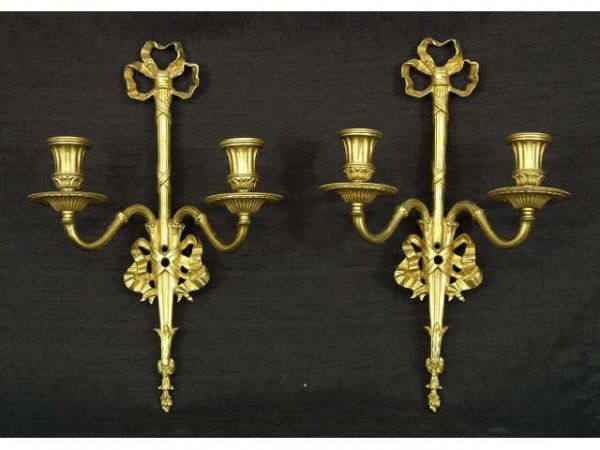Pair of gilt sconces with ribbons on crest.