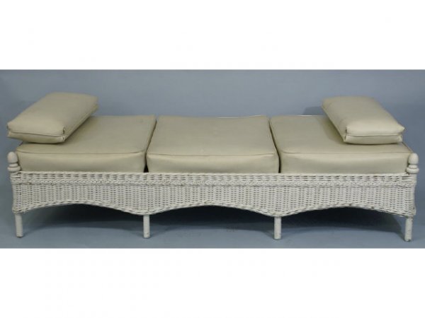 White wicker daybed with vinyl cushions.