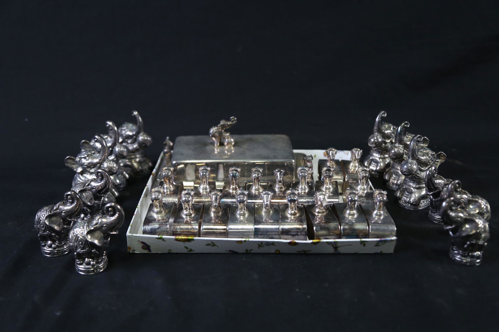 MIXED LOT OF SILVER PLATED ELEPHANT MOTIF ITEMS: MIXED LOT OF SILVER PLATED ELEPHANT MOTIF ITEMS - (19) NAPKIN RINGS, (12) SALT AND PEPPER SHAKERS, (1) BUTTER TRAY, (1) STORAGE TRAY W/LID Height: 4 in. by Width: 11.75 in. by Depth: 11.25