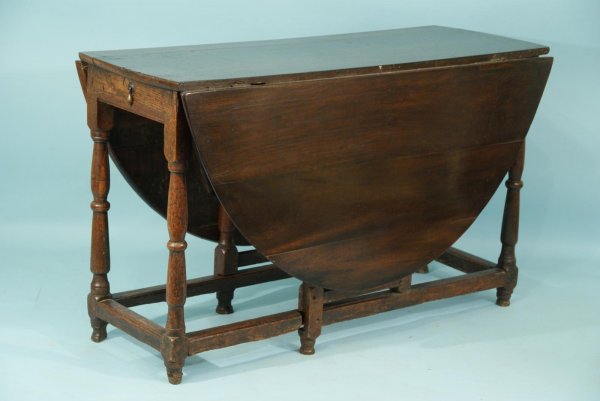 ANTIQUE CHARLES II OAK DROP LEAF TABLE: ANTIQUE ENGLISH CHARLES II MAHOGANY TOP WITH AN OAK BASE DROP LEAF TABLE WITH ONE END DRAWER. LATE 17TH-EARLY 18TH CENTURY. EXTENDS TO 64 IN. Height: 30 in. by Width: 50 in. by Depth: 20 in.