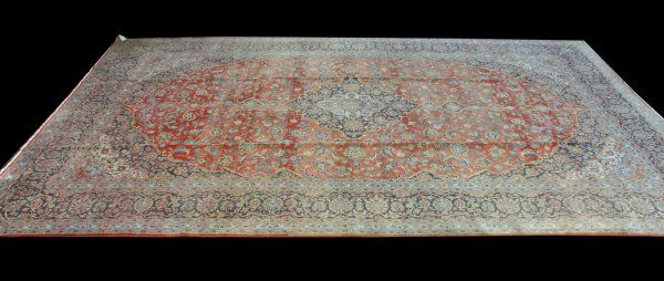 LARGE SEMI-ANTIQUE KASHAN WOOL RUG FROM IRAN: LARGE SEMI-ANTIQUE KASHAN WOOL RUG. COLORS ARE IVORY AND NAVY WITH A RUST FIELD. ORIGIN: IRAN in. by Width: 120 in. in. by Depth: 192