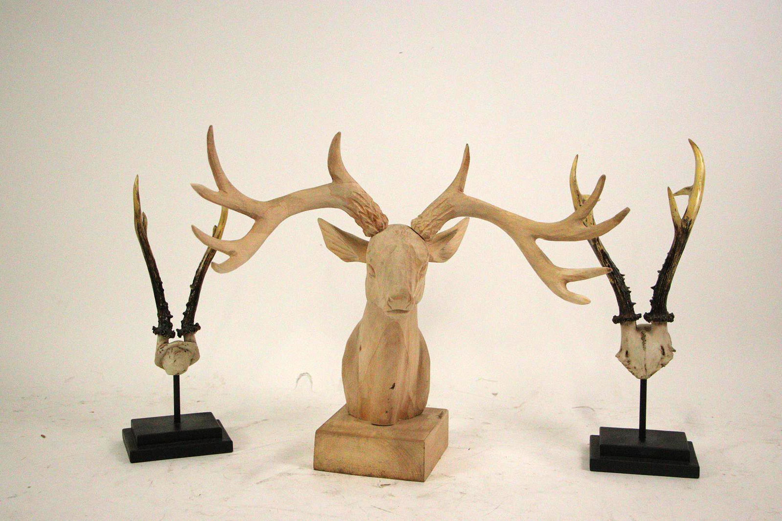 MIXED LOT OF DECORATIVE ANTLERED ANIMAL STATUES: MIXED LOT OF DECORATIVE ANTLERED ANIMAL STATUES - ONE CARVED PINE DEER HEAD AND TWO MOUNTED CAST HORNS.
