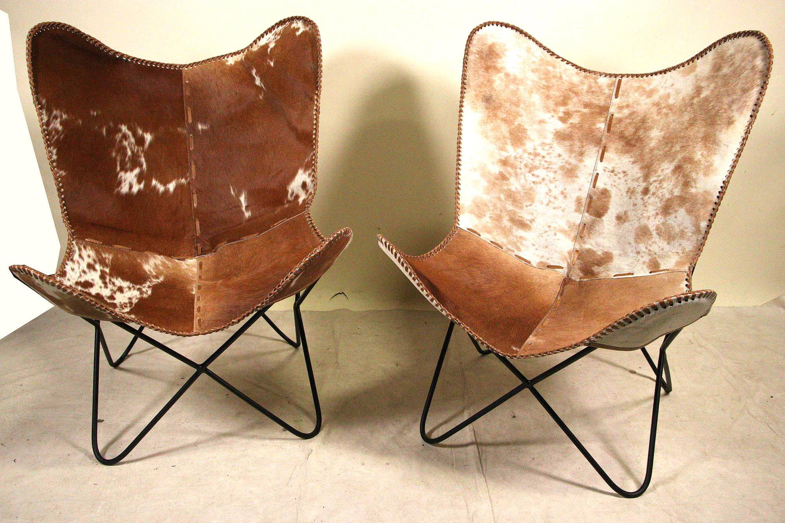 PAIR OF COW HIDE BUTTERFLY CHAIRS ON IRON FRAMES: PAIR OF COW HIDE BUTTERFLY CHAIRS ON IRON FRAMES Height: 37 in. by Width: 27 in. by Depth: 29 in.