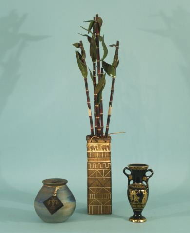 LOT OF THREE DECORATIVE OBJECTS: LOT OF THREE DECORATIVE OBJECTS. ONE SPIRIT RAKU ART JAR, GRECIAN STYLE PORCELAIN JAR, FAUX LUCKY BAMBOO PLANT IN A RESIN PLANTER. Height: 29 and 6 in. by Width: 4 and 3 1/2 in. by Depth: 4 and 3 1/2