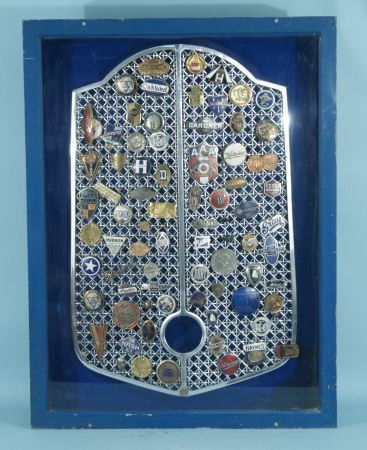 BARNEY OLDFIELD'S VINTAGE CAR GRILLE WITH BADGES: BARNEY OLDFIELD'S VINTAGE CAR GRILLE WITH EXTREMELY COLLECTIBLE RACE CAR GRILLE BADGES IN A SHADOW BOX FRAME. Height: 41 in. by Width: 31 in. by Depth: 4 1/2 in.