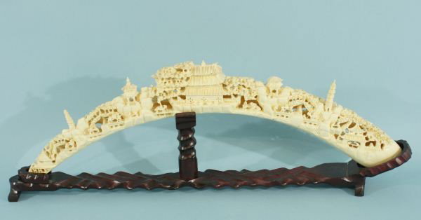CHINESE CAST IVORY AND RESIN DUST CARVED VILLAGE S: CHINESE CAST IVORY AND RESIN TUSK CARVED VILLAGE SCENE ON STAND. Height: 10 in. by Width: 28 1/2 in. by Depth: 3 1/2 in.