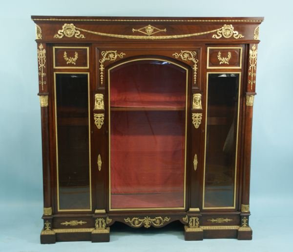 FRENCH MAHOGANY EMPIRE STYLE BOOKCASE, CIRCA 1885: 19th CENTURY FRENCH MAHOGANY EMPIRE STYLE BOOKCASE WITH BRONZE DORE MOUNTS; CARYATID SUPPORTS FLANKING CENTER DOOR; CORNICE WITH TWO MERCURY-HEAD MEDALLIONS; MAHOGANY COLUMNS WITH GILT BRONZE PAPYRUS 