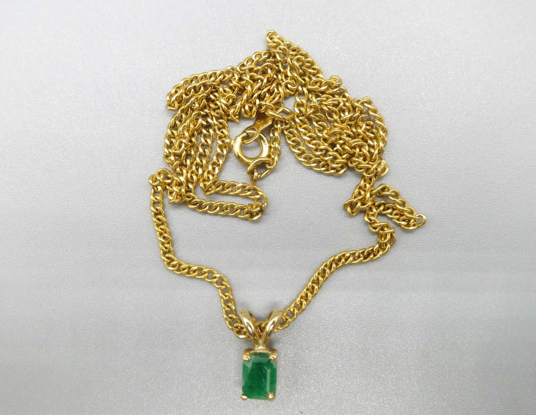 COLUMBIAN GREEN .65CT NATURAL EMERALD NECKLACE: COLUMBIAN VIVID GREEN .65CT NATURAL EMERALD IN A 14KT SETTING ON AN 18 INCH YELLOW GOLD FILLED NECKLACE.