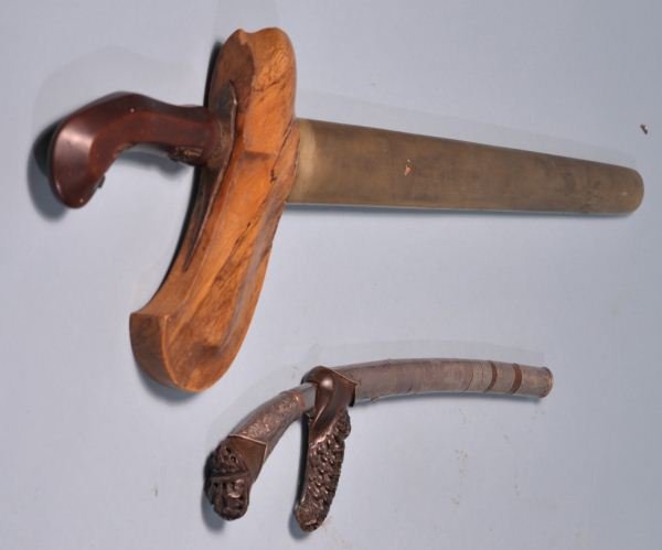 ANTIQUE NORTH AFRICAN DAGGER & A LETTER OPENER: ANTIQUE NORTH AFRICAN DAGGER WITH WOODEN SHEATH AND DAGGER LETTER OPENER IN SILVER METAL SHEATH. Height: 6 1/2 and 3 1/2 in. by Width: 19 and 11 in. by Depth: 1 1/4 and 3/4 in.