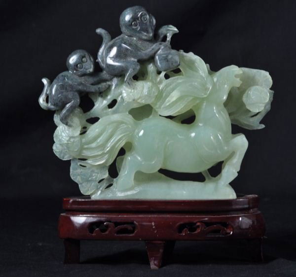 CARVED JADE STATUE OF MONKEYS RIDING A HORSE WITH: CARVED JADE STATUE OF MONKEYS RIDING A HORSE ON WOODEN BASE. Height: 8 in. by Width: 7 in. by Depth: 2 in.