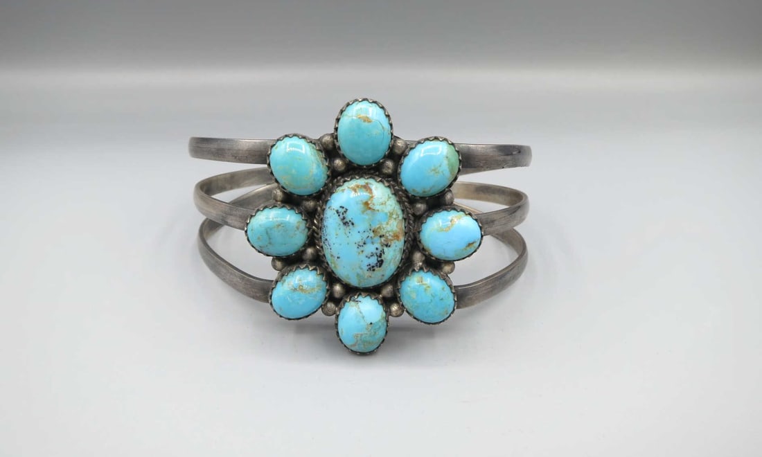STERLING SILVER TURQUOISE FLOWER CUFF BRACELET: STERLING SILVER TURQUOISE FLOWER CUFF BRACELET. Height: 2 in. by Width: 2 15/16 & 2 7/8 in. by Depth: 2 1/4 & 1 3/4 in.