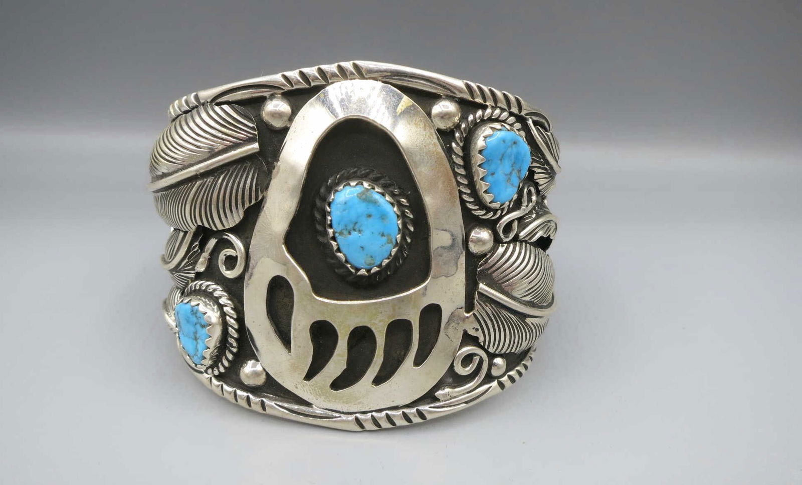 AMERICAN INDIAN SANTA FE BRACELET: AMERICAN INDIAN SANTA FE STERING SILVER THREE-STONE TURQUOISE BEAR PAW MOTIF CUFF BRACELET. Height: 2.5 in. by Width: 3 & 2.5 in. by Depth: 2 1/2 & 1 3/4 in.