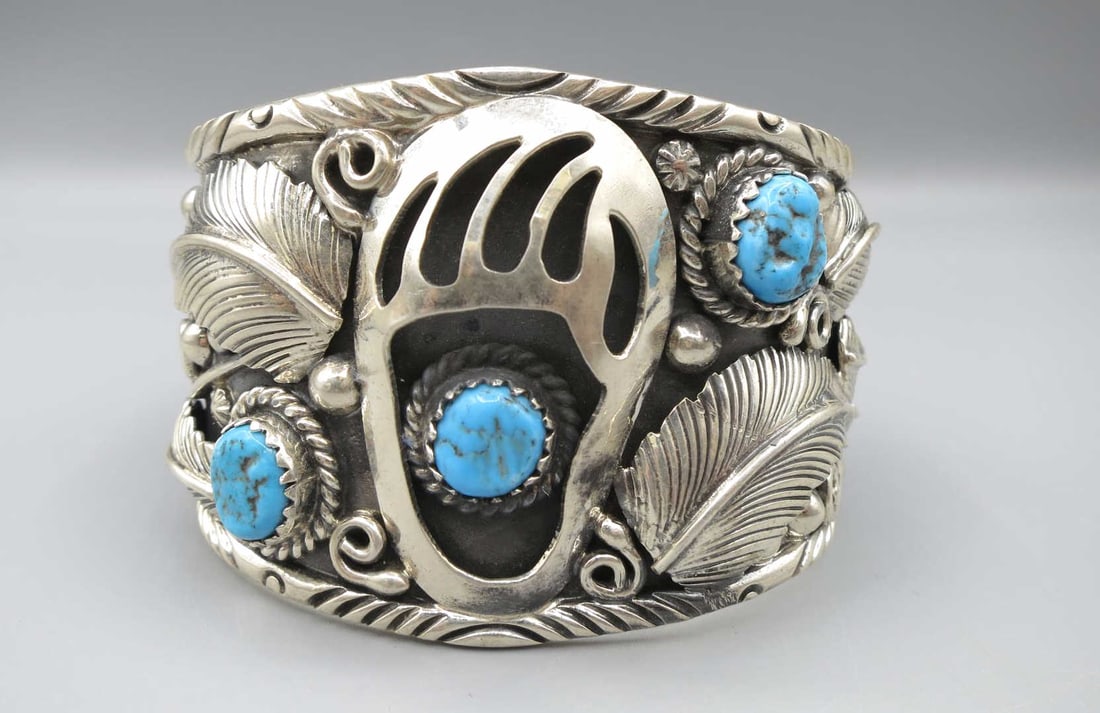 STERLING SILVER TURQUOISE BEAR CLAW MOTIF BRACELET: STERLING SILVER TURQUOISE BEAR CLAW MOTIF CUFF BRACELET. Height: 2 in. by Width: 2 3/4 & 2 3/8 in. by Depth: 2 & 2.5 in.
