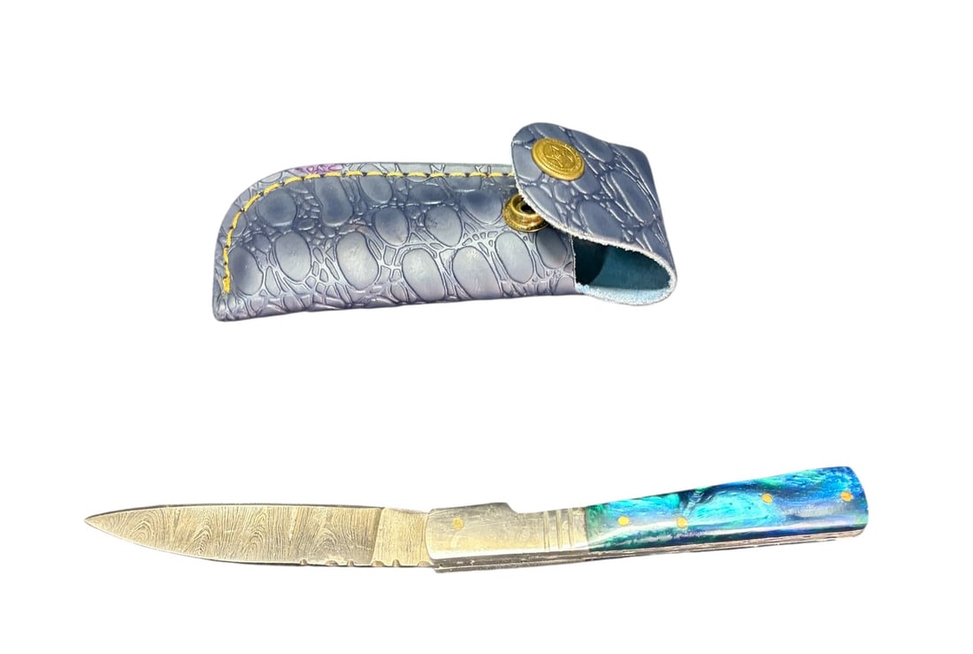 DAMASCUS KNIFE WITH INLAY HANDLE AND LEATHER CASE: DAMASCUS FOLDING KNIFE WITH INLAY HANDLE AND LEATHER CASE. Height: 8 in. by Width: 1.5 in. by Depth: .5 in.