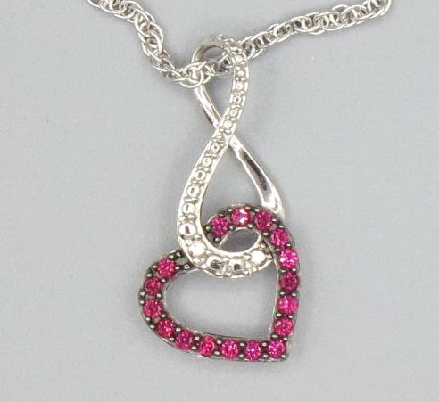 CZ PAVE RUBY & DIAMOND STERLING SILVER PENDANT: CZ PAVE RUBY & DIAMOND PENDANT ON STERLING SILVER CHAIN. Height: 1 in. by Width: 1/2 in. by Depth: 1/4 in.