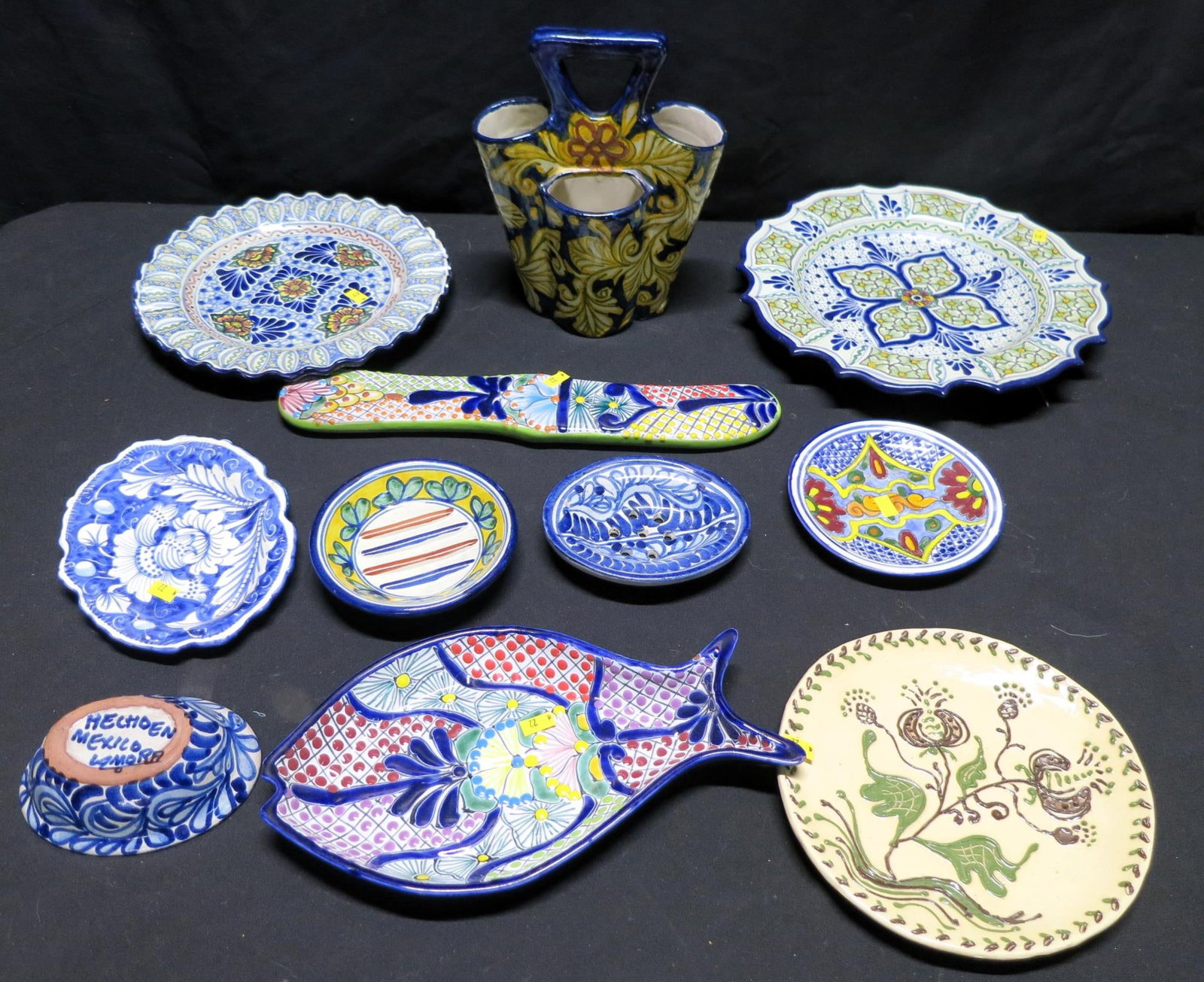 MIXED LOT OF 11 MEXICAN TALAVERA DECORATIVE PIECES: MIXED LOT OF 11 HAND MADE MEXICAN TALAVERA DECORATIVE PIECES. Vase=10"h x 8"w x 5"d. Knive=2.5"h x 15"w x 3/4"d. Fish=7 x 11.5"w x 1.5"d. Largest plate=1.5"h x 12.5"wide. Smallest=1.25"h x