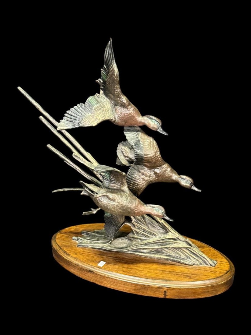 BRONZE SCULPTURE OF 3 DUCKS: BRONZE SCULPTURE OF 3 DUCKS IN FLIGHT ON A OVAL WOODEN BASE Height: 18.5 in. by Width: 18 in. by Depth: 9