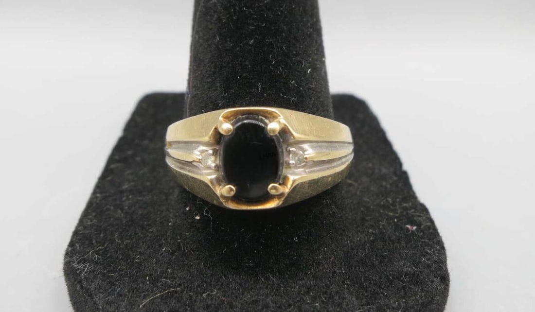 MEN'S 10KT YELLOW GOLD BLACK ONYX & DIAMOND RING: MEN'S 10KT YELLOW GOLD BLACK ONYX & DIAMOND RING. THIS CLASSIC MEN'S RING FEATURES A PRONG SET OVAL BLACK ONYS CENTER STONE ACCENTED WITH TWO SMALL DIAMONDS. 4 GRAMS T.W. SIZE 10.5.