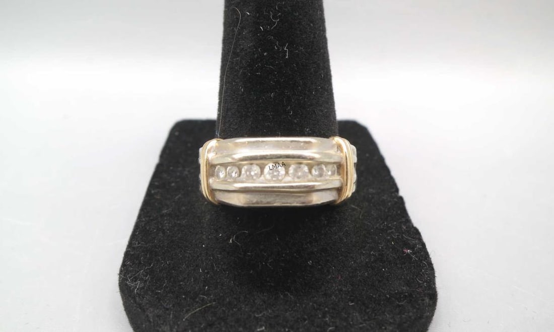 TWO-TONE 10KT GOLD CHANNEL SET DIAMOND RING: MEN'S 10KT TWO-TONE GOLD CHANNEL SET DIAMOND RING. FEATURING A ROW OF ROUND BRILLIANT CUT DIAMONDS FRAMED IN WHITE GOLD WITH DISTINCT YELLOW GOLD SHOULDER ACCENTS. 5 GRAMS T.W. SIZE 9.