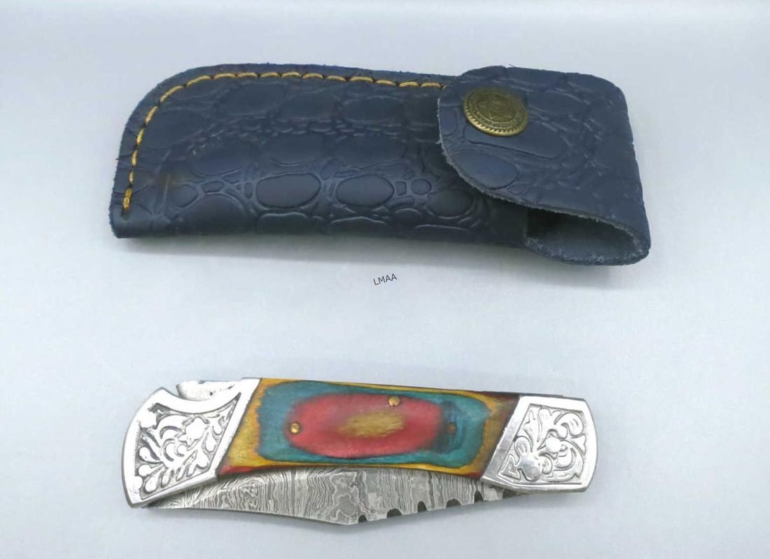 HANDMADE FOLDING POCKET KNIFE: HANDMADE FOLDING POCKET KNIFE WITH DAMASCUS STYLE BLADE AND PAKKAWOOD HANDLE AND EMBOSSED AND STITCHED LEATHER SHEATH. Height: 1.25 in. by Width: 4 & 7 in. by Depth: .5 in.