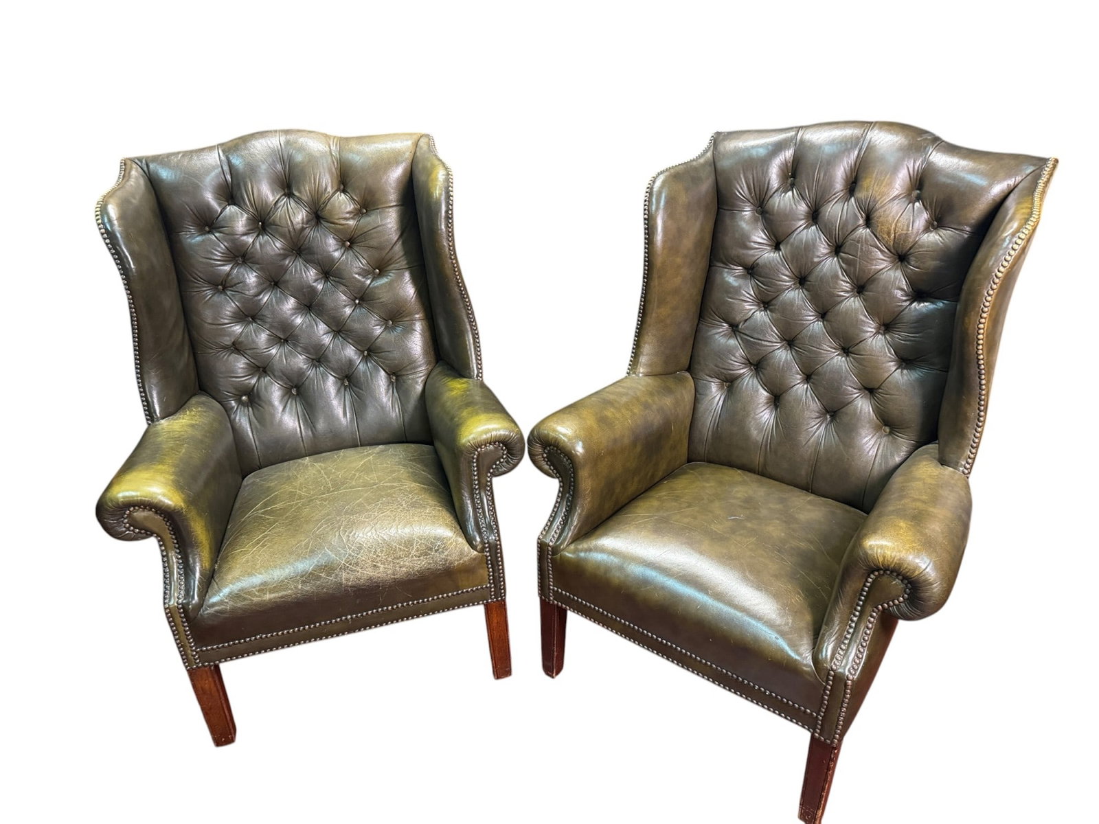 PAIR OF ENGLISH BUTTON TUFTED WING CHAIRS: PAIR OF ENGLISH BUTTON-TUFTED WING CHAIRS. LIBRARY GREEN. SEAT HEIGHT: 18 INCHES. Height: 43 in. by Width: 32 in. by Depth: 32 in.