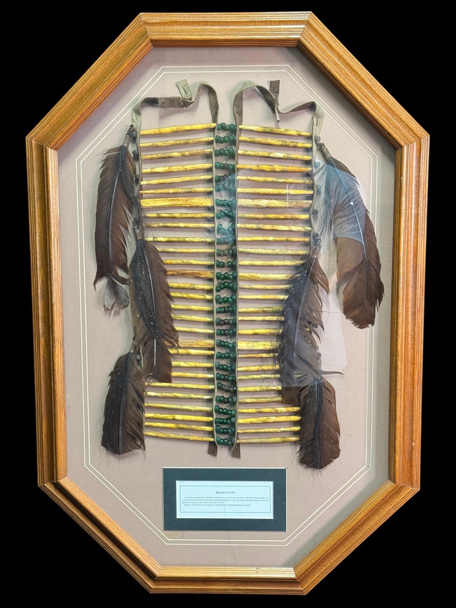 NATIVE AMERICAN -STYLE BONE BREASTPLATE DISPLAY.: NATIVE AMERICAN -STYLE BONE BREASTPLATE DISPLAY. CONSTRUCTED WITH ROWS OF BONES, GREEN BEADS, LEATHER TIES AND FEATHER DROPS. Height: 31 in. by Width: 21 in. by Depth: 1.25 in.