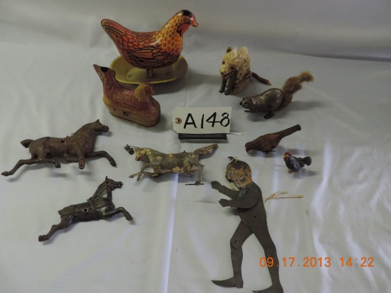 Mixed lot of 9 animals and puppet: Two cast iron horses, one missing foot, one missing tail. Large tin man moves with string. Fox wind up. Bird wind up. Small chickens cast iron. Squirrel with fuzzy tail.