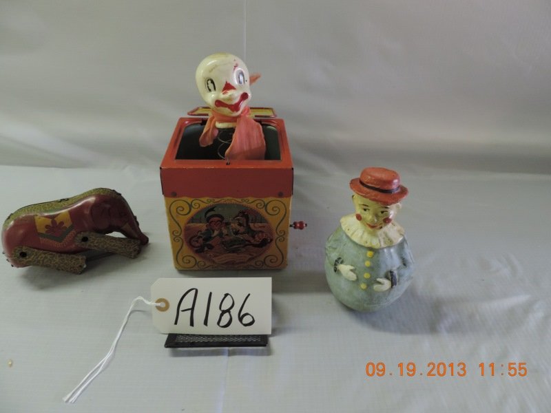 Mixed lot of four toys: Mattel “Jolly Tune” jack in the box, metal elephant on wheels, rolly clown out of paper mache. a186