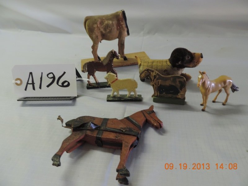 Mixed lot of 7 animal toys: Misc. animals. Wooden horse with harness, cow with wooden base,small tin dog on wheels, one lamb on stand, and one rubber horse.