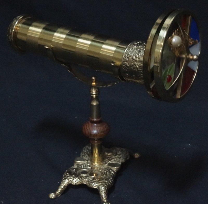 BRASS KALEIDOSCOPE WITH A BASE: BRASS KALEIDOSCOPE WITH A BASE. Height: 11 in. by Width: 11 in. by Depth: 6 in.
