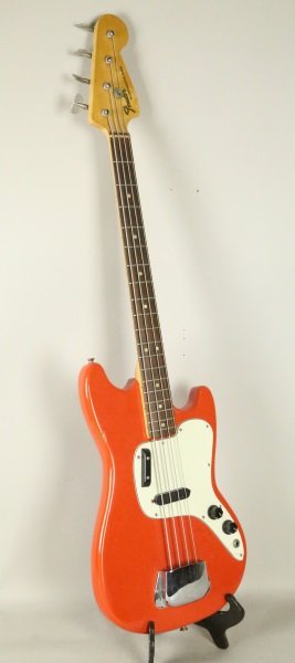 1965 FENDER MUSICMASTER BASS GUITAR: 1965 FENDER MUSICMASTER RED AND WHITE BASS GUITAR WITH CASE. SERIAL NUMBER 622561. FAIR CONDITION-CARRYING CASE HANDLE BROKEN.