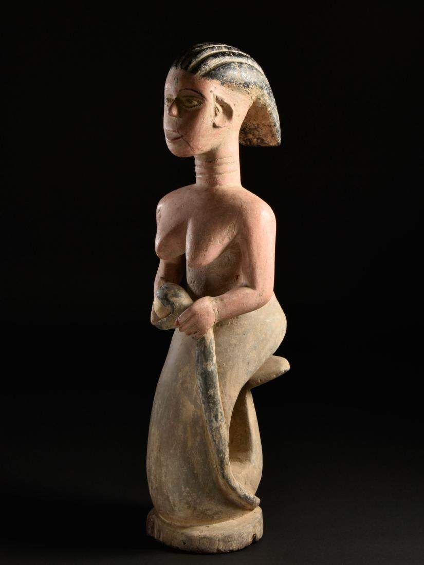 Ewe Figur, "Mami Wata" / Ewe Mermaid / Ghana: 44 Figur, "Mami Wata" Ewe, Ghana / Togo Ohne Sockel / without base Holz. H 83 cm. Provenienz: Nachlass René David (1928-2015), Zürich. Mami Wata ist ein afrikanischer Wassergeist, dessen Ursprung in