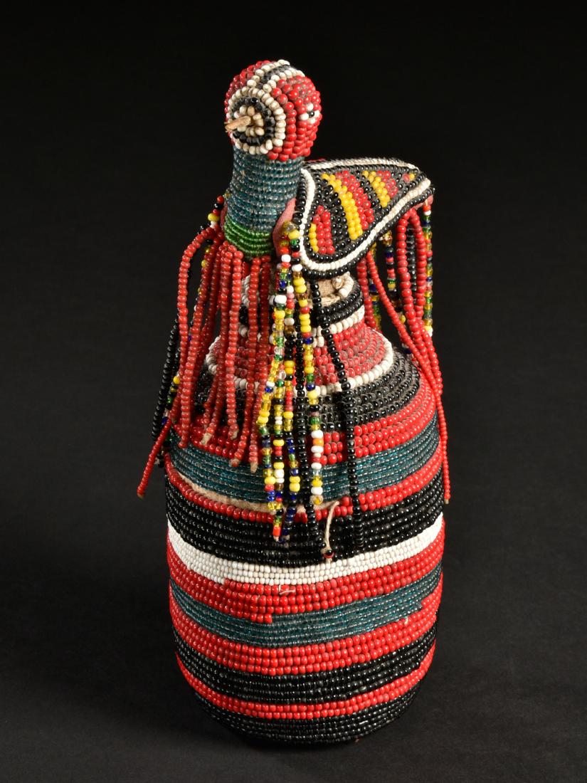A Yoruba Beaded Glass Bottle: Perlenbestickte Glasflasche Yoruba, Nigeria Ohne Sockel / without base Glas, mit Glasperlen überzogen. H 20 cm. Provenienz: Nachlass René David (1928-2015), Zürich. Ausgestellt: Musée Internationa