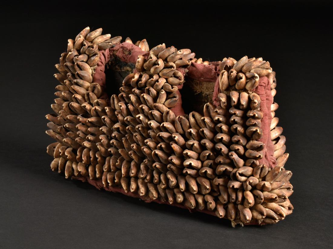 A Coat of a Twin Figure Pair "ere ibeji": Ibeji-Kleid Yoruba, Nigeria H 16 cm. B 28 cm. Provenienz: Galerie Walu, Zürich. Mit Kaurischnecken versehener Mantel eines Zwillingsfiguren-Paares "ere ibeji". CHF 100 / 200 EUR 86 / 172