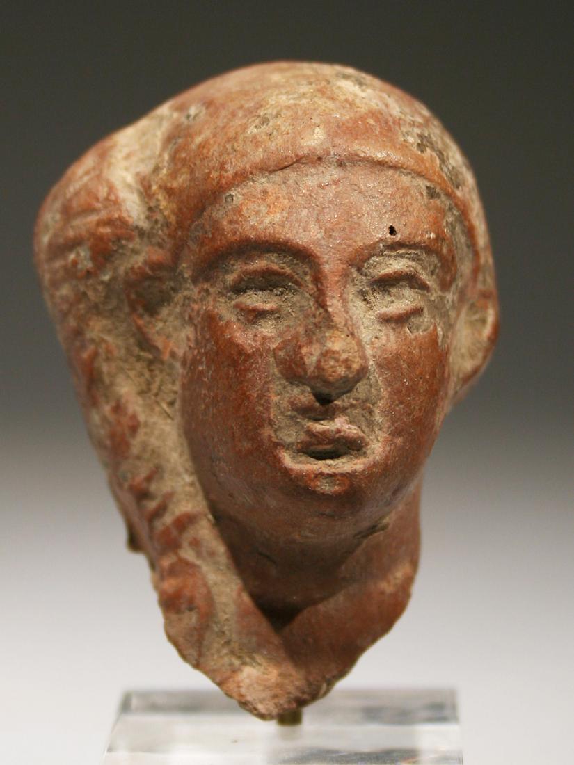 An Egyptian Head of Harpokrates: KÖPFCHEN DES HARPOKRATES Ägypten, 3. - 2. Jh. v. Chr. Mit Sockel / with base Keramik. H 4,5 cm. Provenienz: Sammlung Hofmann, Berlin (vor 1939). CHF 75 / 150 EUR 64 / 129