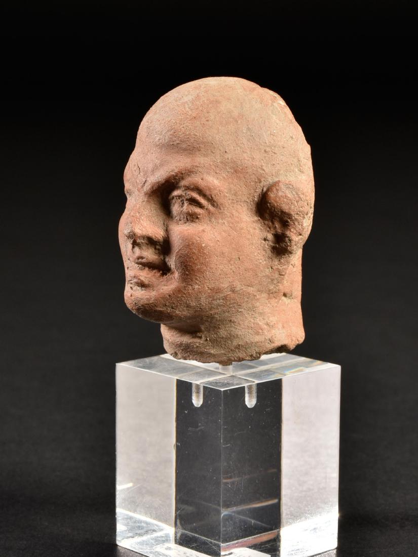 An Egyptian Head of a Priest (?): KÖPFCHEN EINES PRIESTERS (?) Alexandrinisch, Ägypten, 3.-2. Jh. v. Chr. Mit Sockel / with base Keramik. H 4,1 cm. Provenienz: Sammlung Hofmann, Berlin (vor 1939). CHF 75 / 150 EUR 64 / 129