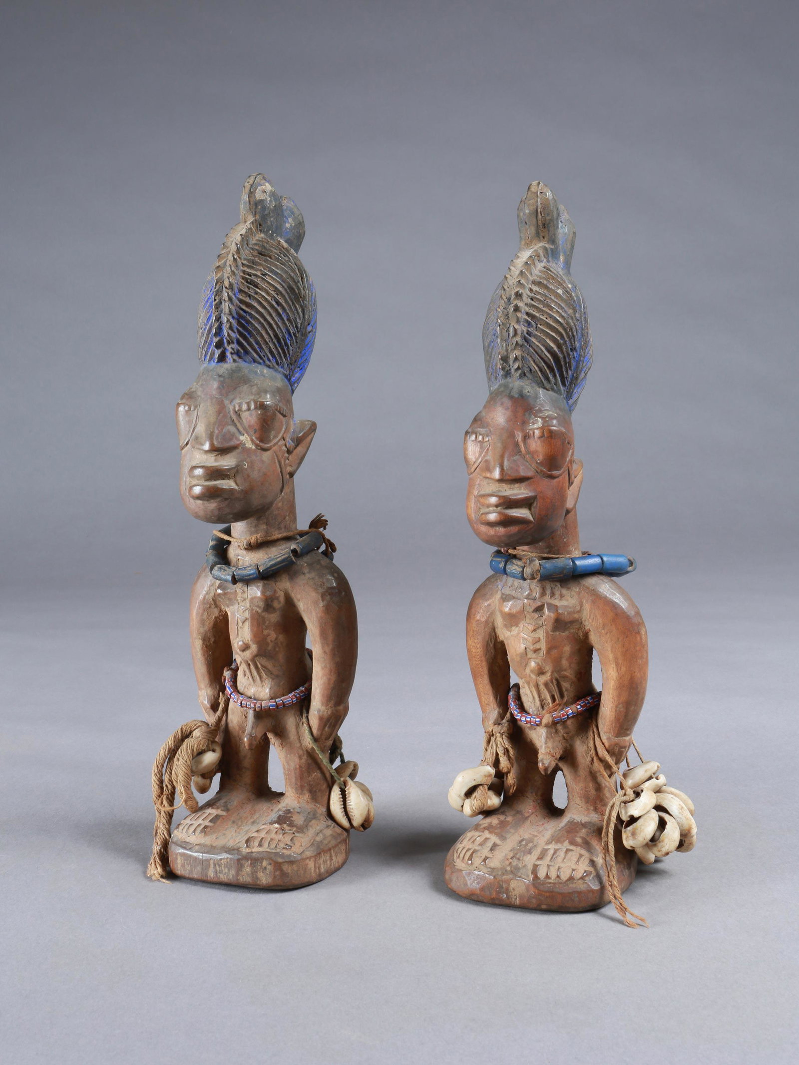 A Yoruba Pair of Twin Figures, "ere ibeji": Zwillingsfigurenpaar, "ere ibeji" Yoruba, Nigeria Ohne Sockel / without base Holz, Glasperlen, Kaurischnecken. H 29 cm. 30 cm. Provenienz: Walter Häusler, Thurgau. 1960er Jahre in Nigeria erworben. �