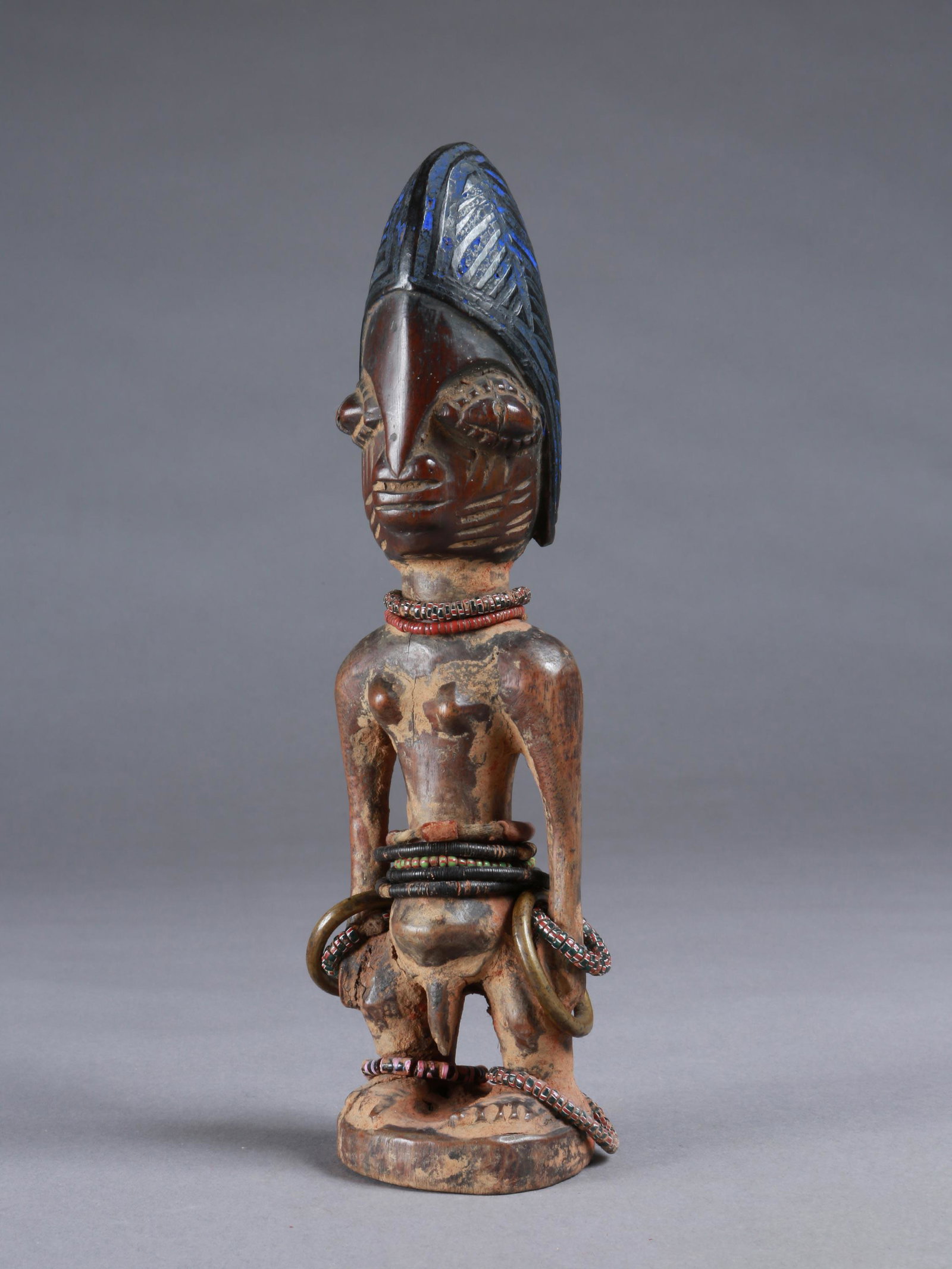 A Yoruba Twin Figure, "ere ibeji": Zwillingsfigur, "ere ibeji" Yoruba, Nigeria Ohne Sockel / without base Holz, Gelbguss, Glasperlen. H 26 cm. Provenienz: Walter Häusler, Thurgau. 1960er Jahre in Nigeria erworben. Über Zwillinge wurd
