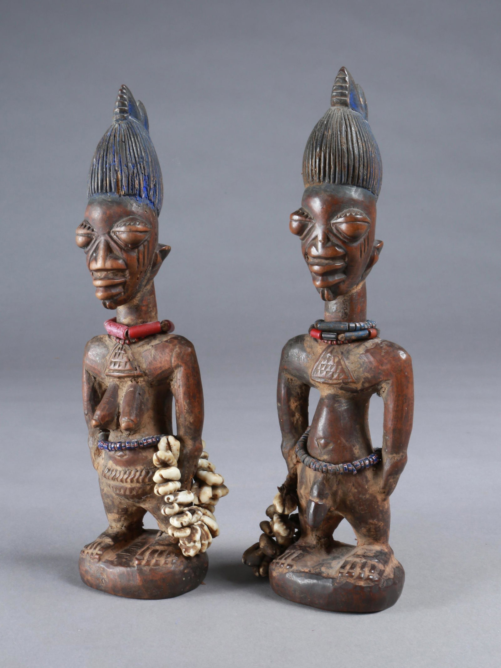 A Yoruba Pair of Twin Figures, "ere ibeji": Zwillingsfigurenpaar, "ere ibeji" Yoruba, Nigeria Ohne Sockel / without base Holz, Glasperlen, Kaurischnecken. H 28,5 cm und 29 cm. Provenienz: Walter Häusler, Thurgau. 1960er Jahre in Nigeria erworb