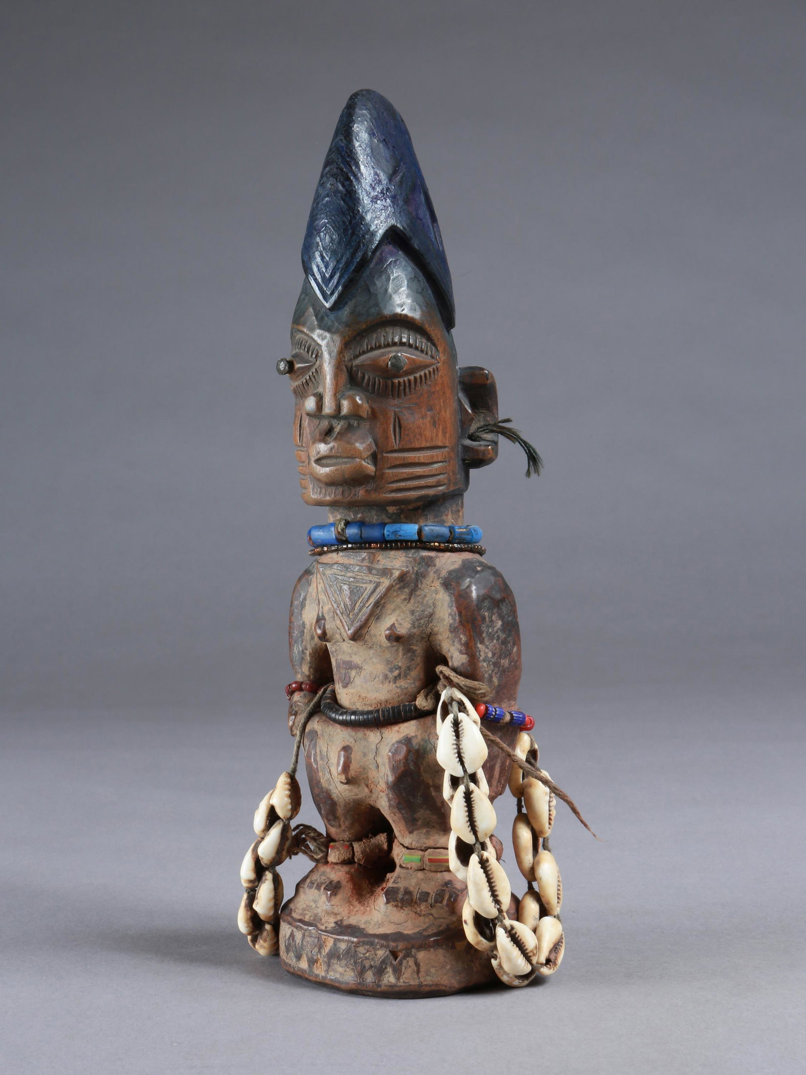 A Yoruba Twin Figure, "ere ibeji": Zwillingsfigur, "ere ibeji" Yoruba, Nigeria Ohne Sockel / without base Holz, Glasperlen, Kaurischnecken. H 28 cm. Provenienz: Walter Häusler, Thurgau. 1960er Jahre in Nigeria erworben. Über Zwilling