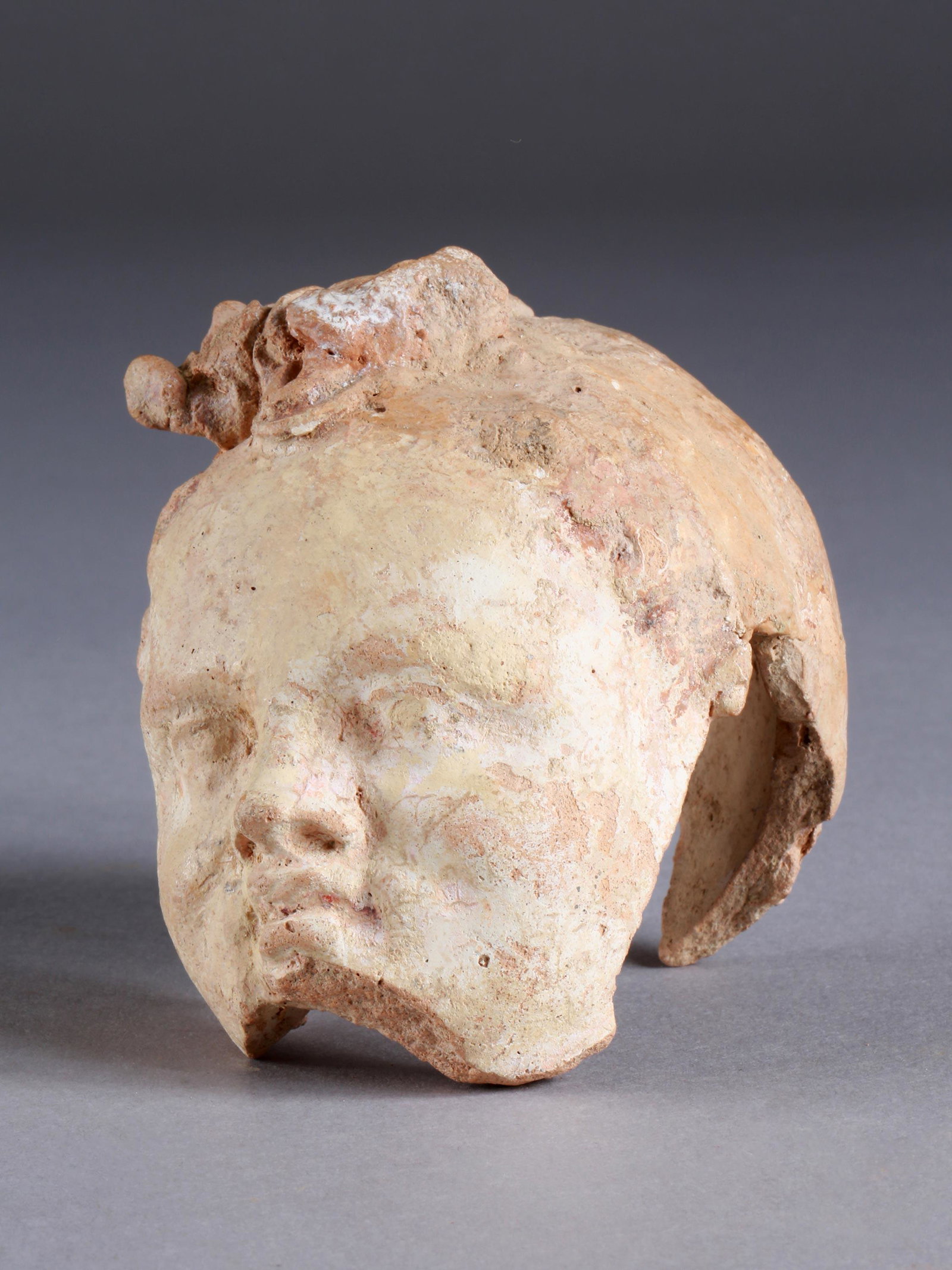A Greek Head of a Child: KOPF EINES KINDES Westgriechisch Ohne Sockel / without base Keramik, weisser Überzug, rote Farbe.. H 10 cm. Provenienz: Privatsammlung Schweiz. Publiziert: Cahn's Quarterly 4/2017, Seite 13. 4. Jh. v