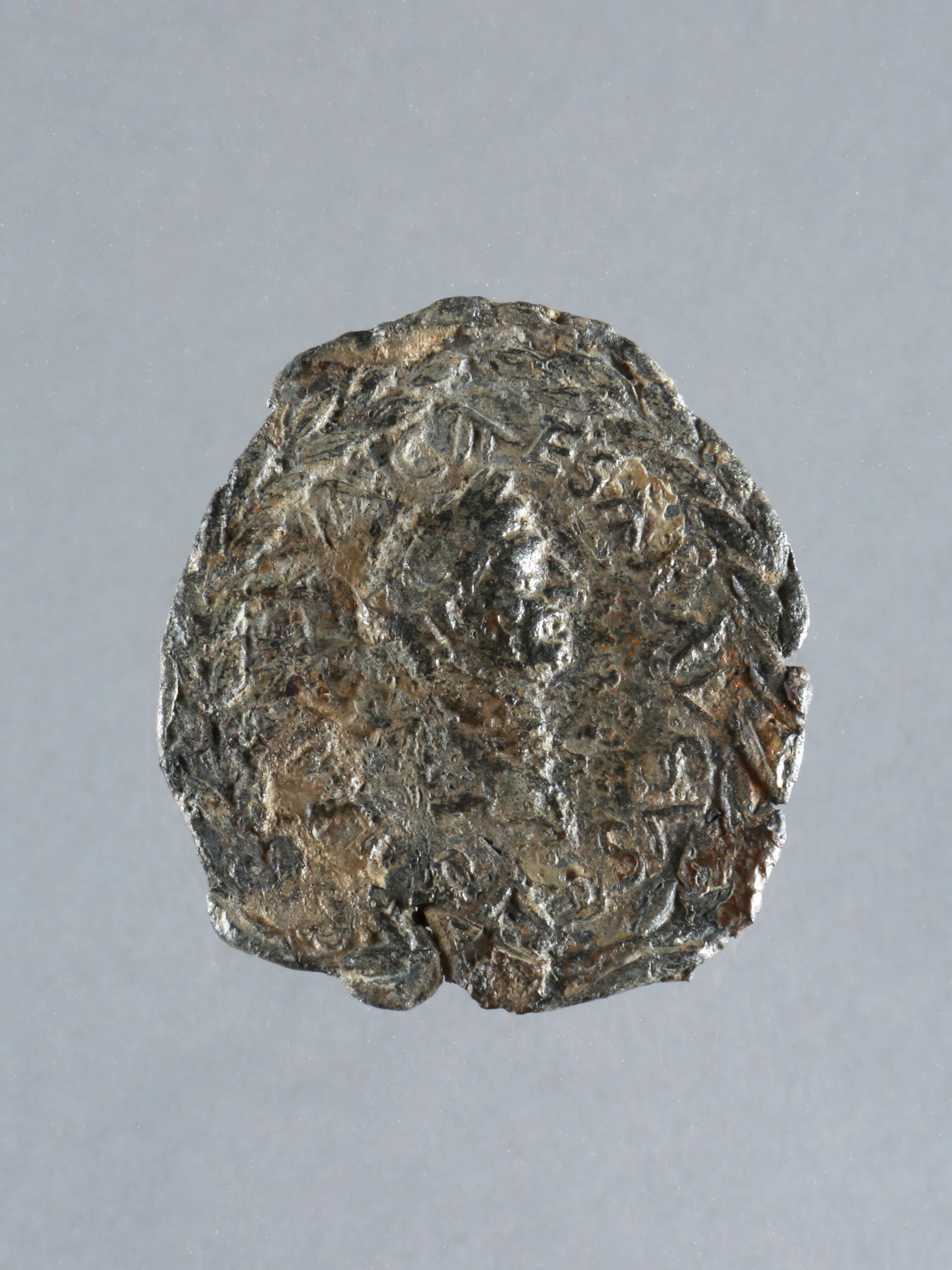 A Roman Applique with Kaiser Nerva: APPLIKE MIT KAISERS NERVA IM LORBEERKRANZ Römisch Ohne Sockel / without base Blei. H 5,5 cm. Provenienz: Privatsammlung Schweiz. Spätes 1. Jh. n. Chr. Legende (soweit lesbar): NERVA CAESAR AUGUSTUS.
