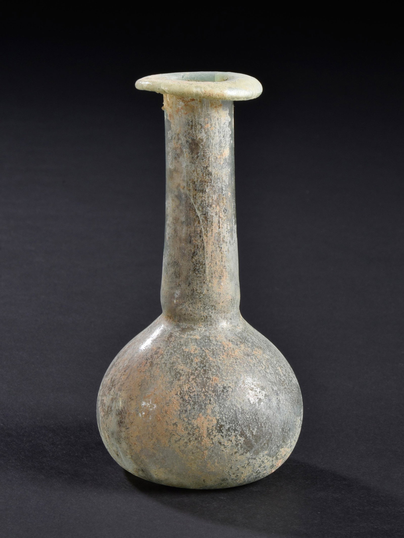 A Roman Bottle: FLÄSCHCHEN Römisch, Östliches Mittelmeergebiet Ohne Sockel / without base Glas. H 9,3 cm. Provenienz: Sammlung B.K., Berlin (Aus Beirut, erworben 18.3.1975). 1. - 3. Jh. n. Chr. Rim restored / Mün