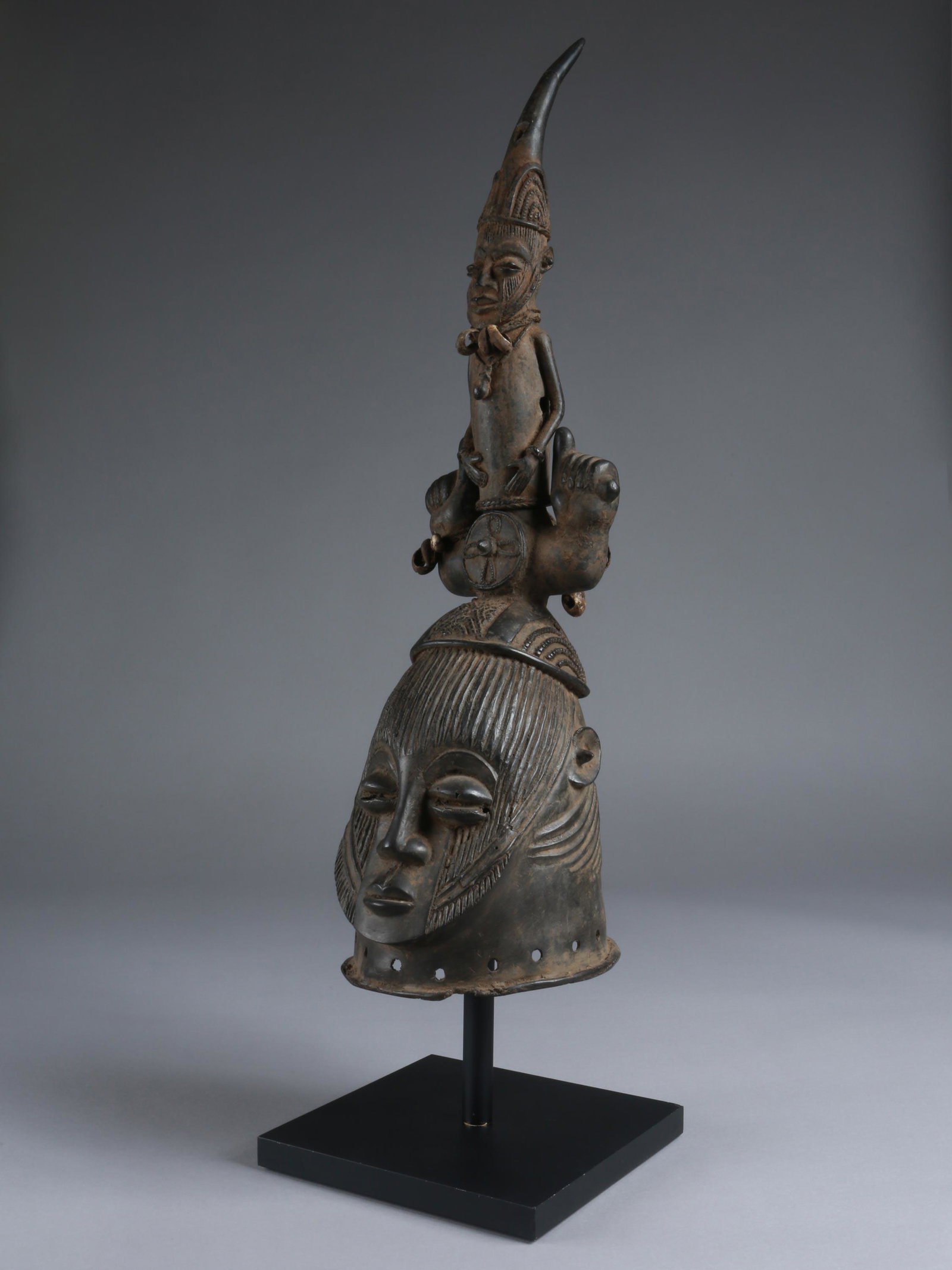 An Igala Headdress with removable Horn: Kopfaufsatz mit abnehmbaren Horn Igala, Nigeria Mit Sockel / with base Gelbguss. H 62 cm. Provenienz: deutsche Privatsammlung, Berlin. CHF 1 000 / 2 000 EUR 860 / 1 720