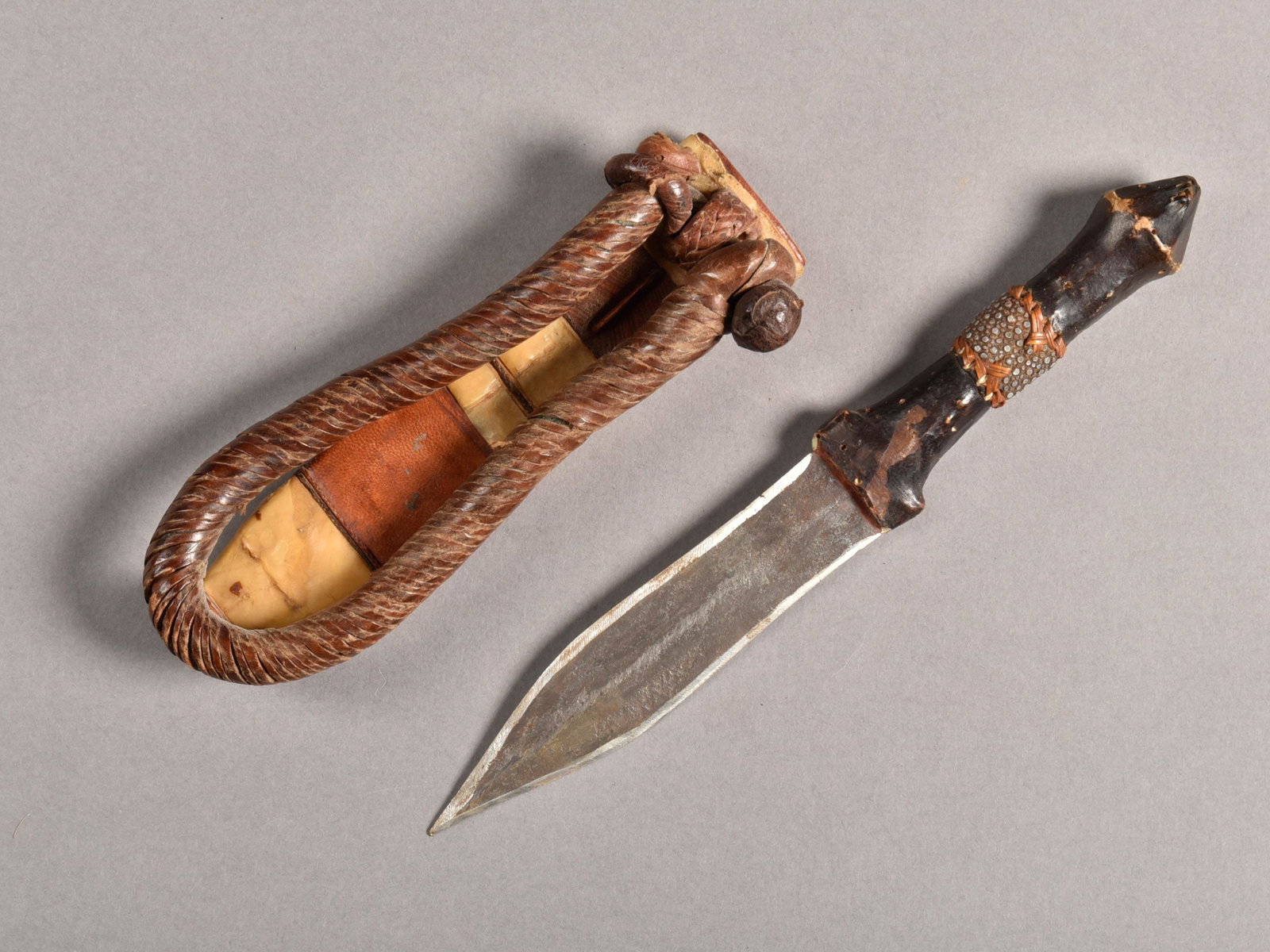 A Bariba Dagger with Sheath: Dolch mit Scheide Bariba, Togo, Benin, Nigeria Ohne Sockel / without base Eisen, Holz, Leder. H 24,5 cm. Provenienz: Helmut und Marianne Zimmer, Zürich. Zeremonialwaffen zeichnen sich durch sorgfält