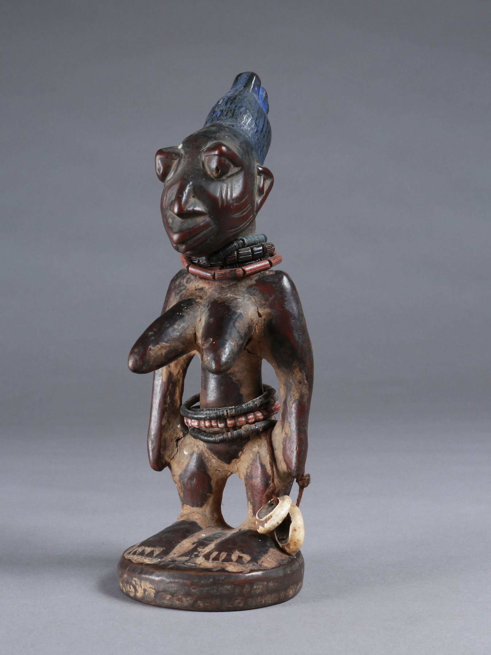 A Yoruba Twin Figure, "ere ibeji": Zwillingsfigur, "ere ibeji" Yoruba, Nigeria Ohne Sockel / without base Holz, Glasperlen, Kaurischnecken. H 28 cm. Provenienz: Walter Häusler, Thurgau. 1960er Jahre in Nigeria erworben. Über Zwilling