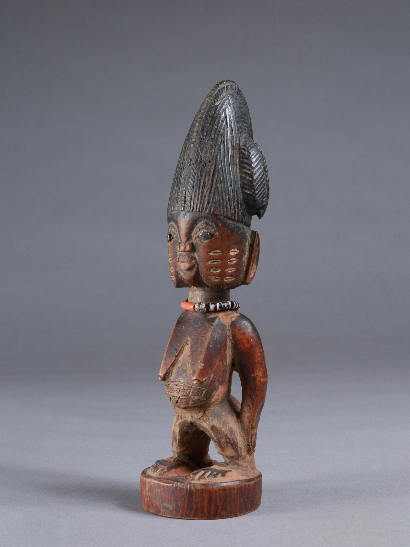 A Yoruba Twin Figure, "ere ibeji": Zwillingsfigur, "ere ibeji" Yoruba, Nigeria Ohne Sockel / without base Holz, Glasperlen, Metall. H 25,5 cm. Provenienz: Walter Häusler, Thurgau. 1960er Jahre in Nigeria erworben. Über Zwillinge wurd