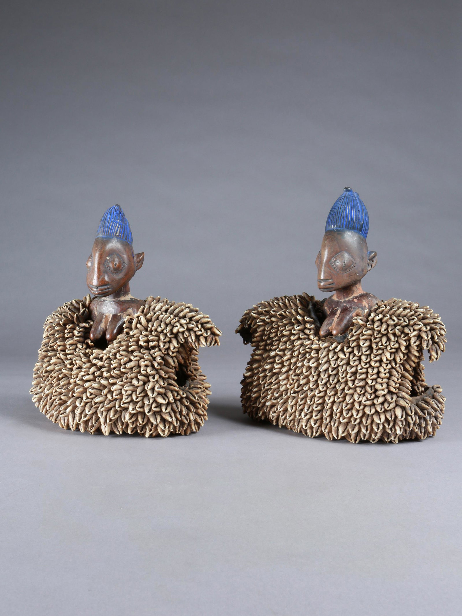 A Yoruba Pair of Twin Figures, "ere ibeji": Zwillingsfigurenpaar, "ere ibeji" Yoruba, Nigeria Ohne Sockel / without base Holz, textil, Kaurischnecken. H 28,5 cm und 29 cm. Provenienz: - Walter Häusler, Thurgau. 1960er Jahre in Nigeria erworben