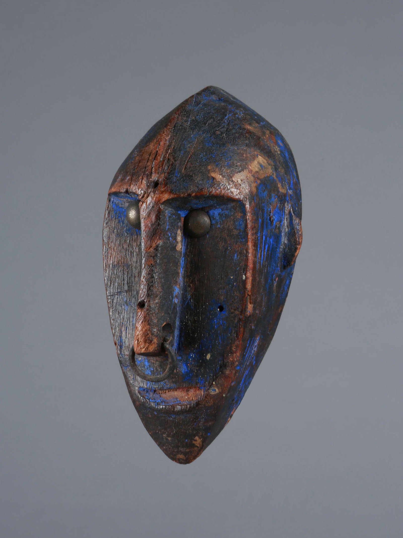 A Bamana Miniature Mask: Miniatur-Maske Bamana, Mali Ohne Sockel / without base Holz, Polsternägel. H 10,5 cm. Provenienz: Helmut und Marianne Zimmer, Zürich. Amulettartige Miniatur einer wesentlich grösseren, ähnlich ges