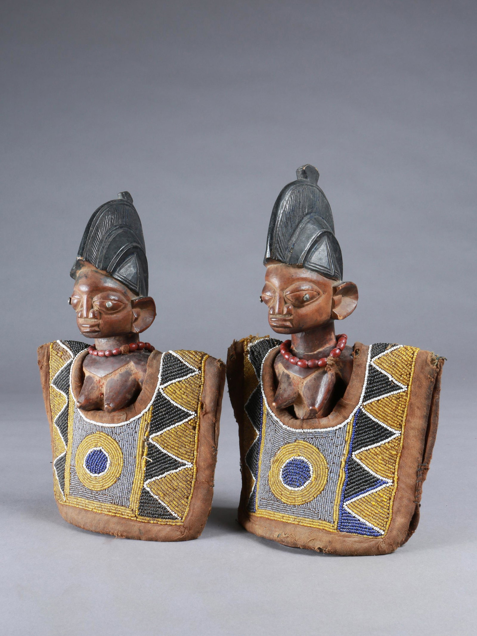 A Yoruba Pair of Twin Figures, "ere ibeji": Zwillingsfigurenpaar, "ere ibeji" Yoruba, Nigeria, Ekiti Ohne Sockel / without base Holz, Textil, Glasperlen. H 31 und 33 cm. Provenienz: Walter Häusler (1944-2020), Tägerwilen. 1960er Jahre in Nige